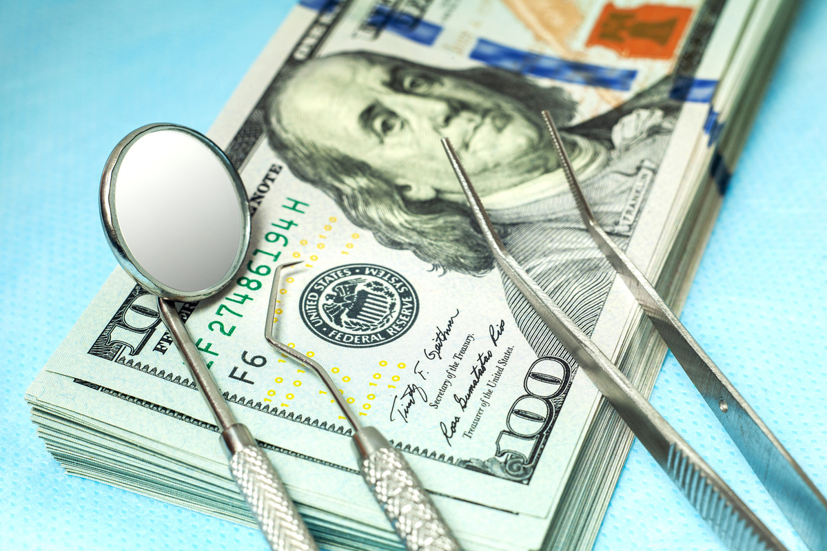 Dental tools on a stack of cash representing braces cost