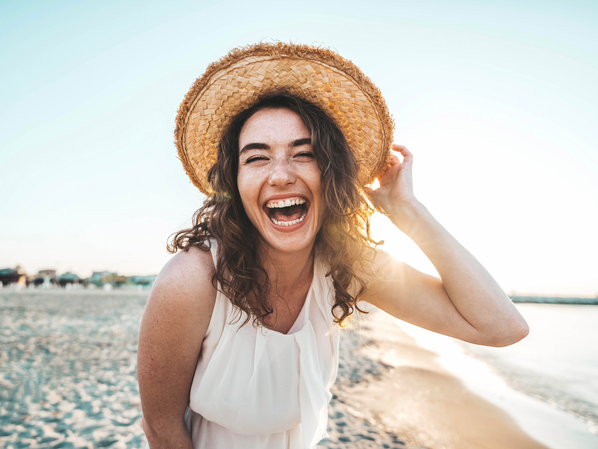 Happy young woman smiling at the beach