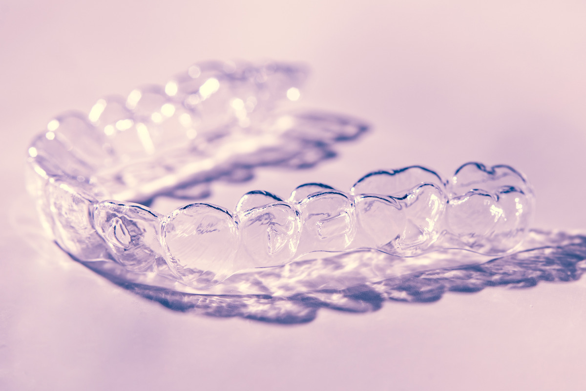 Invisible dental aligners on a pink background