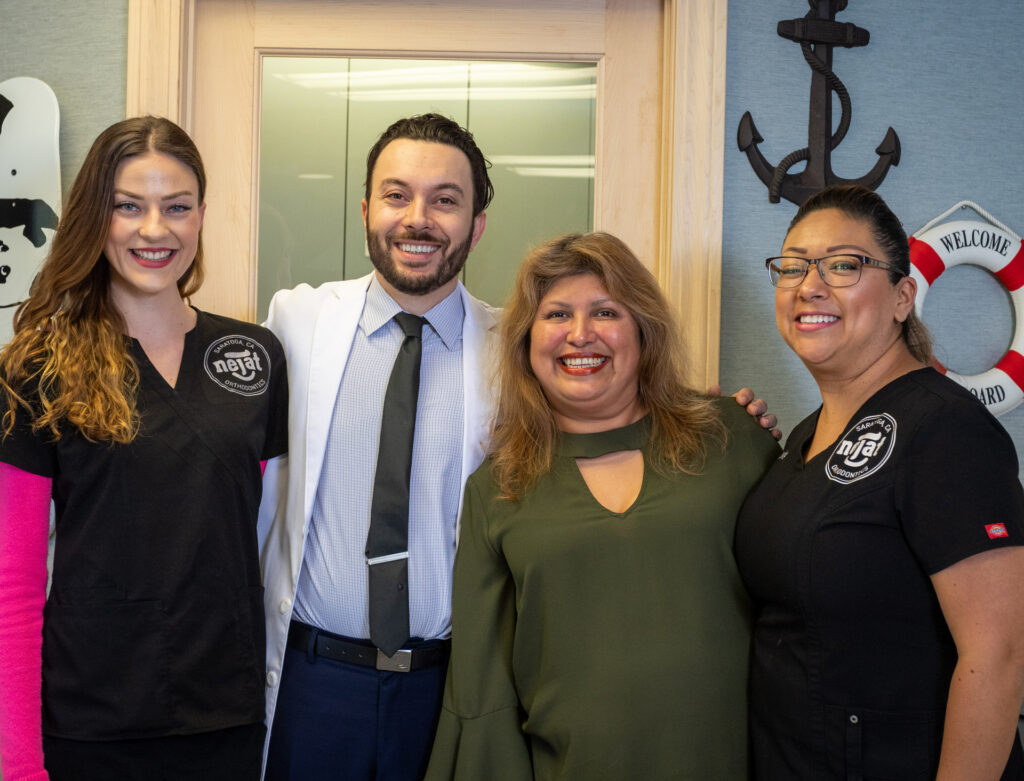 Nejat Orthodontics team posing together in the office